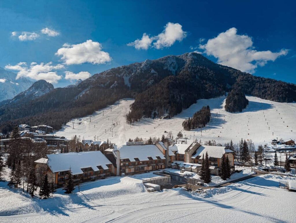 Hotel Kompas Kranjska Gora exterior with direct ski slope access and panoramic Alpine views – only true ski-in/ski-out luxury hotels Slovenia, winter 2025-26