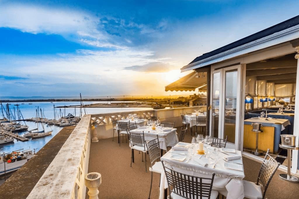 Best luxury hotels in Syracuse. Sunset view from hotel Ortigia terrace.