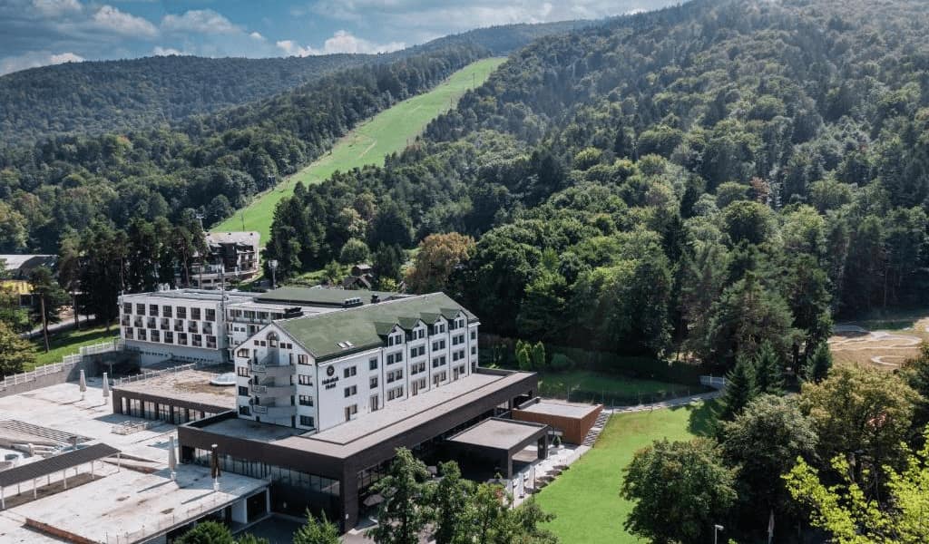Best Hotels in Mariborsko Pohorje. Summer view of the hotel, slope and hill.