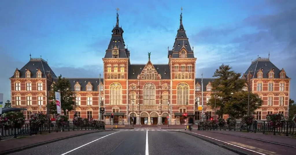The monumental 19th-century Gothic-Renaissance facade of the Rijksmuseum in Amsterdam, the most recognizable landmark in the Netherlands and the centerpiece for the best historic hotels in the Netherlands.