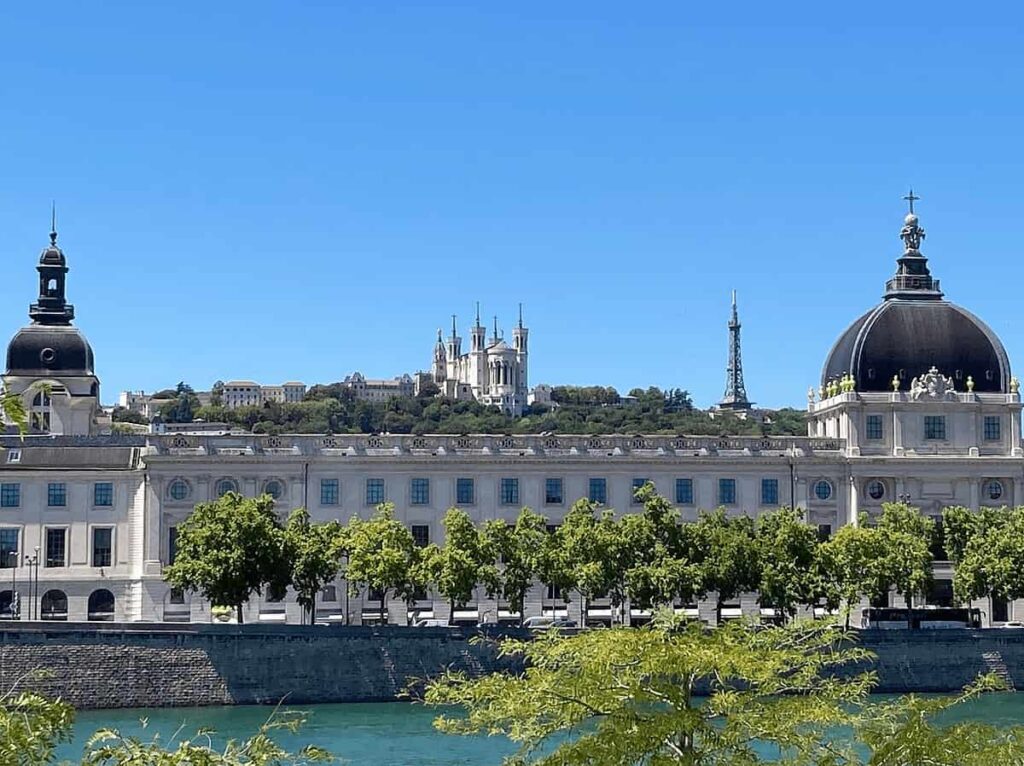 The grand historic stone facade of the InterContinental Hotel-Dieu, one of the best hotels in Lyon, seen from the riverbank.