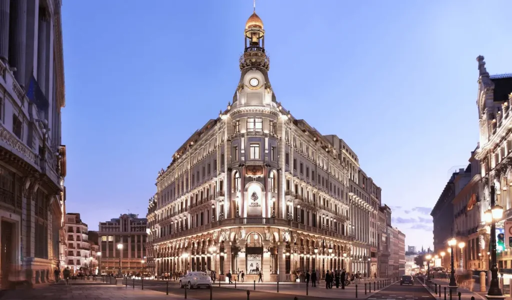 The iconic triangular facade and restored 19th-century bank headquarters architecture of the Four Seasons, one of the best hotels in Madrid.