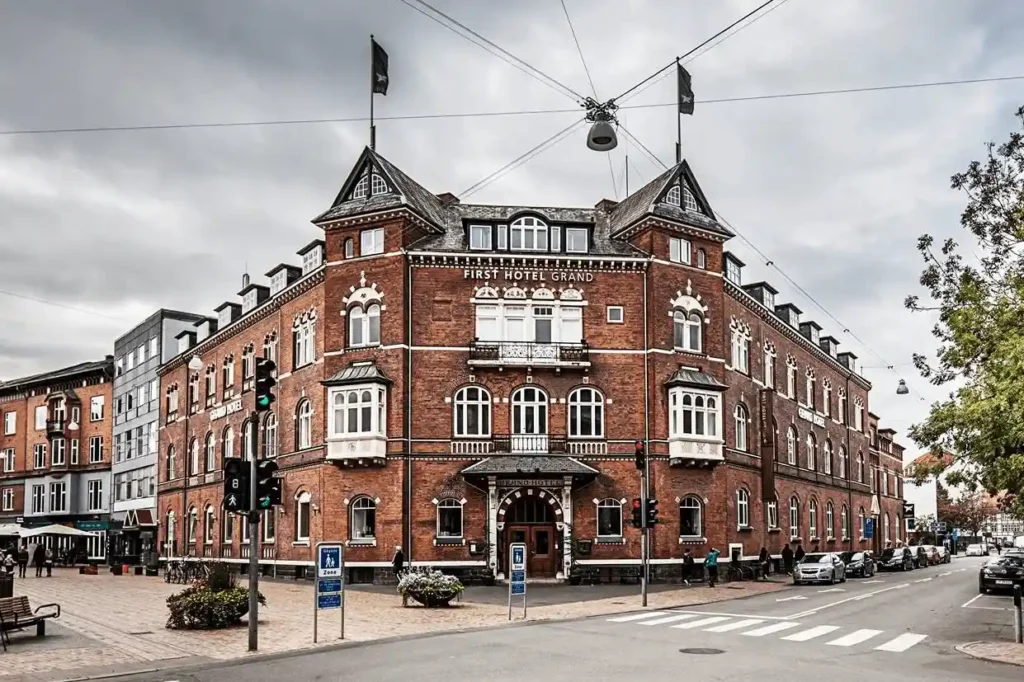 The monumental 1897 brick-and-sandstone facade of First Hotel Grand, showcasing the neo-renaissance craftsmanship that defines the best hotels in Odense.