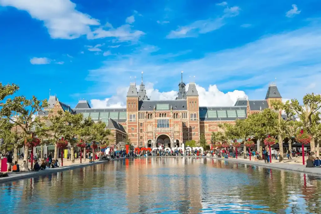The monumental 19th-century Gothic-Renaissance facade of the Rijksmuseum in Amsterdam, the most recognizable landmark in the Netherlands and the centerpiece for the best historic hotels in the Netherlands.