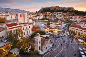 A panoramic sunset view of Monastiraki Square and the Acropolis in Athens, the primary urban hub for the best historic hotels in Greece.