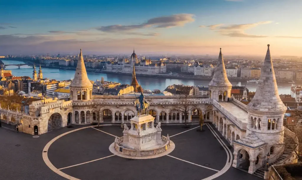 An audit of best historic hotels in Hungary: A wide view of the Neo-Romanesque Fisherman's Bastion in Budapest featuring its seven fairytale stone towers and the bronze equestrian statue of Saint Stephen.