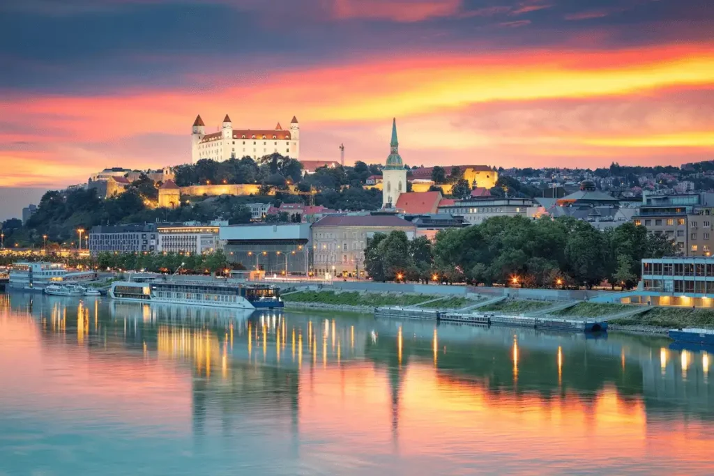 An audit of the best historic hotels in Slovakia: A panoramic view of the Bratislava Castle and the Danube River, representing the imperial heritage of the capital.
