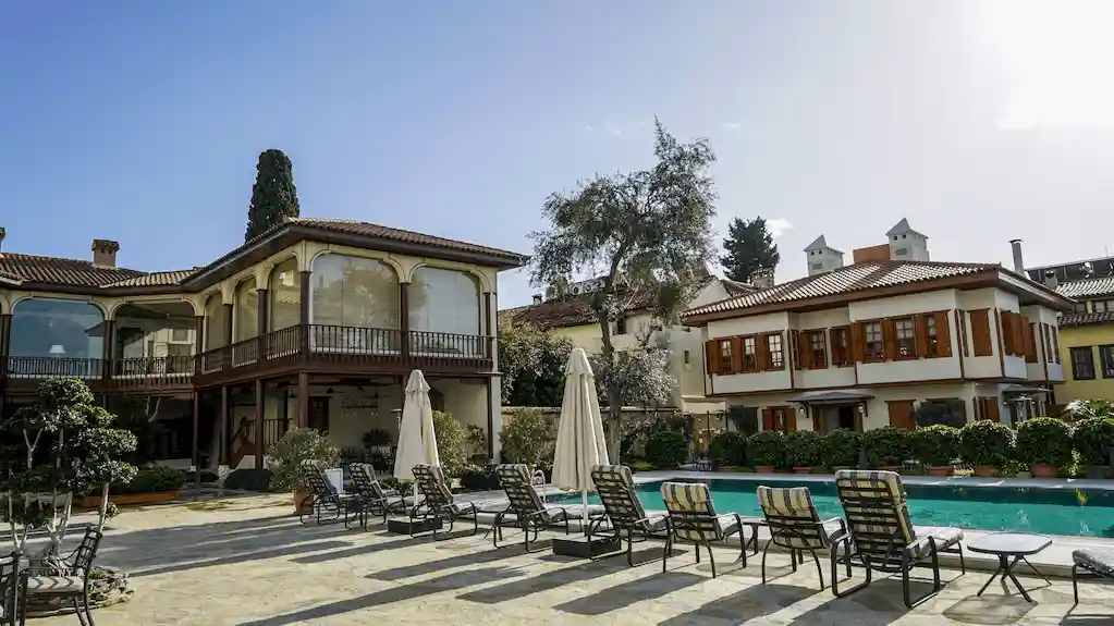 The meticulously restored 19th-century facade and courtyard swimming pool of RuinAdalia Hotel, a premier historic landmark and verified asset in the best hotels in Antalya Turkey.