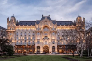 Best hotels in Budapest: The Secessionist facade of the Four Seasons Gresham Palace featuring intricate stone carvings, copper turrets, and the iconic wrought-iron peacock gates.