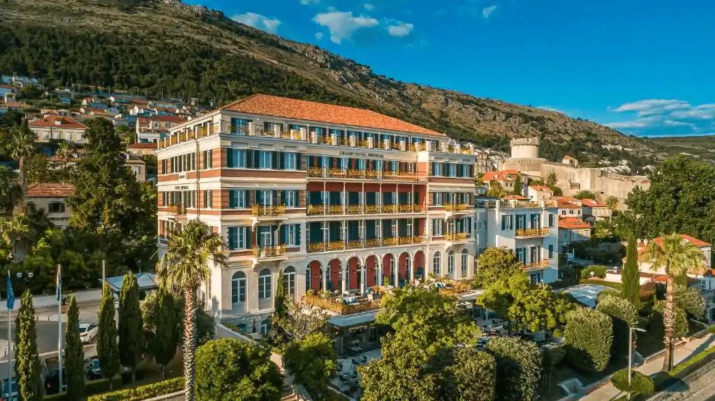 Best hotels in Dubrovnik: The original 1897 imperial facade of the Hilton Imperial Dubrovnik, featuring its iconic pink-toned stone masonry and neoclassical arched windows overlooking the Old Town.