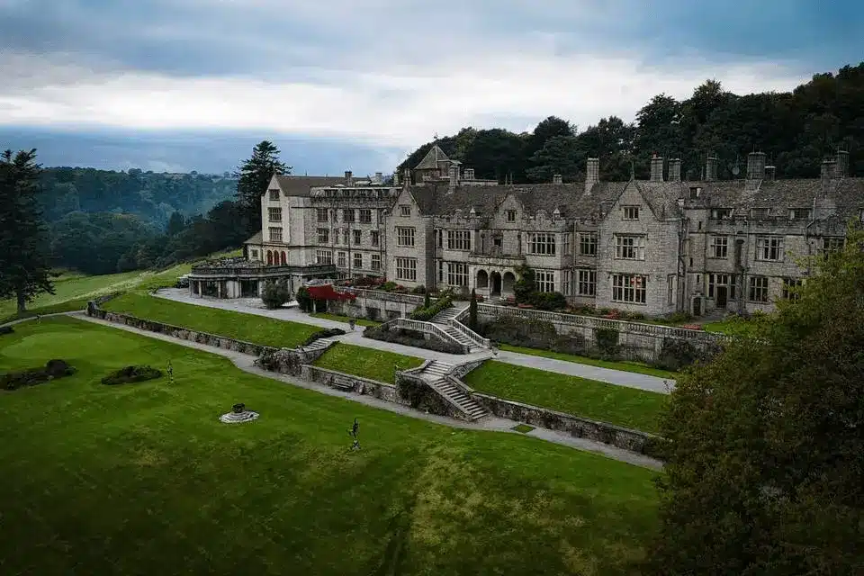 Aerial perspective of the Neo-Elizabethan stone facade of Bovey Castle overlooking the championship golf course and the private 275-acre Dartmoor estate.