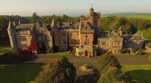 The 19th-century sandstone Scottish Baronial facade of Glenapp Castle, featuring David Bryce’s signature turrets and crenellations overlooking the Irish Sea.
