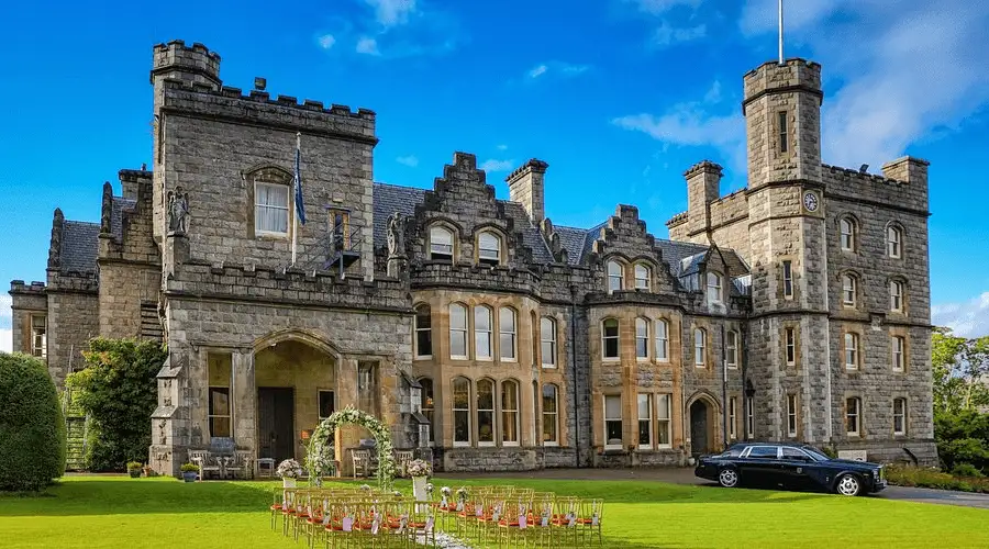 The 19th-century Scottish Baronial facade of Inverlochy Castle Hotel, featuring dove-grey stone turrets at the foot of Ben Nevis.