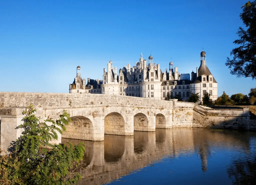 Exterior stone facade of Relais de Chambord overlooking the historic stone bridge and moated grounds of the Château de Chambord estate.