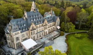 The grand Tudor-style facade of Schlosshotel Kronberg, showcasing intricate half-timbering, ornate gables, and red-tiled roofing, originally built as a royal residence for Empress Victoria.