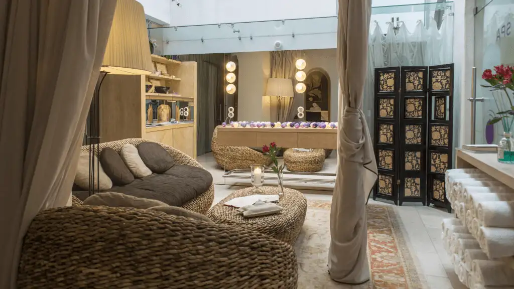 The private wellness sanctuary at Dome Hotel Riga featuring woven lounge furniture, soft natural linens, and a tranquil atmosphere for post-travel recovery.