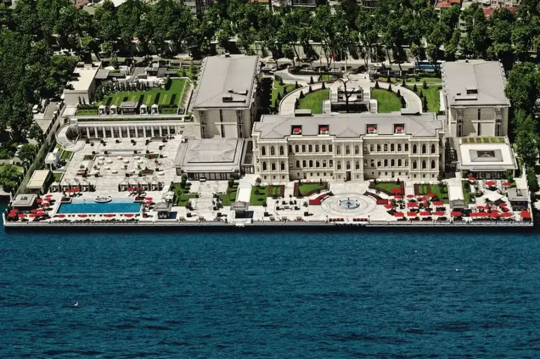 An aerial perspective of the Four Seasons Hotel Istanbul at the Bosphorus, highlighting the 19th-century Atik Pasha Palace wing and the expansive marble waterfront terrace with its heated outdoor pool overlooking the strait.