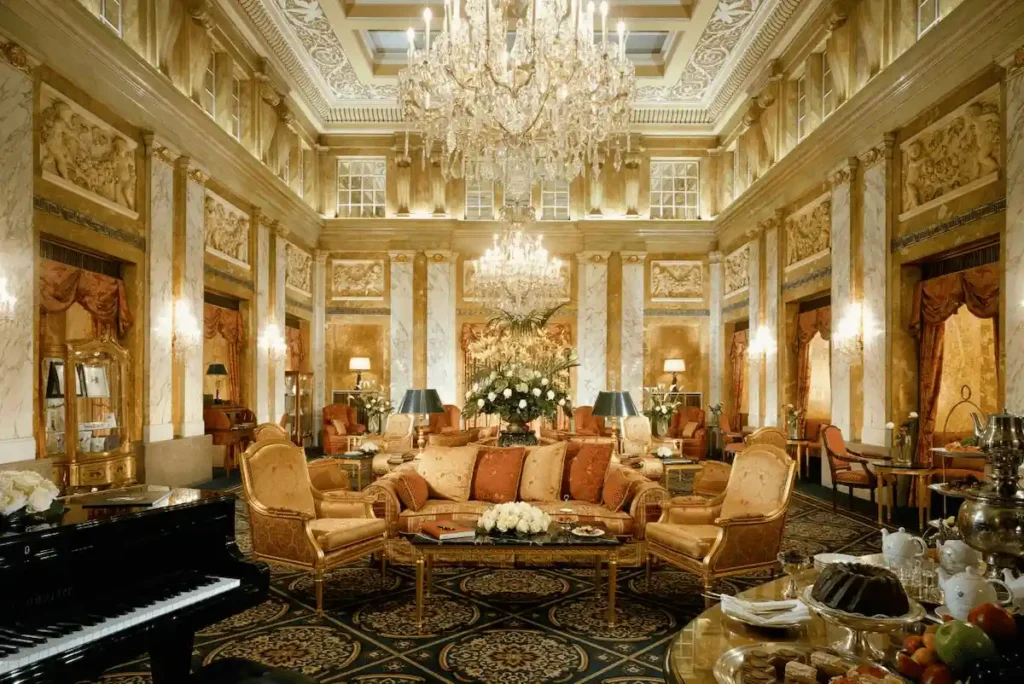 The opulent 1873 Hallensalon at Hotel Imperial Vienna, a Luxury Collection Hotel, featuring a massive crystal chandelier, ornate marble pillars, and gold stucco ceilings in the former palace.