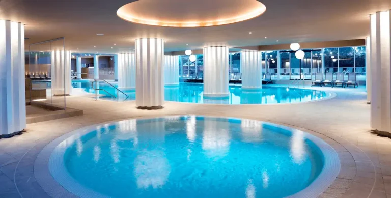 The luminous Sea Spa at Hotel Slovenija Terme & Wellness LifeClass, featuring heated seawater pools, illuminated white columns, and a sophisticated indoor wellness atmosphere overlooking the Portorož coast.