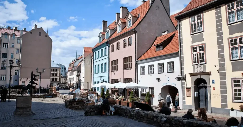 The restored 13th-century building complex of Konventa Sēta Hotel in Old Riga, featuring a series of colorful historic facades, cobblestone paths, and the "Convent Yard" inner courtyard.