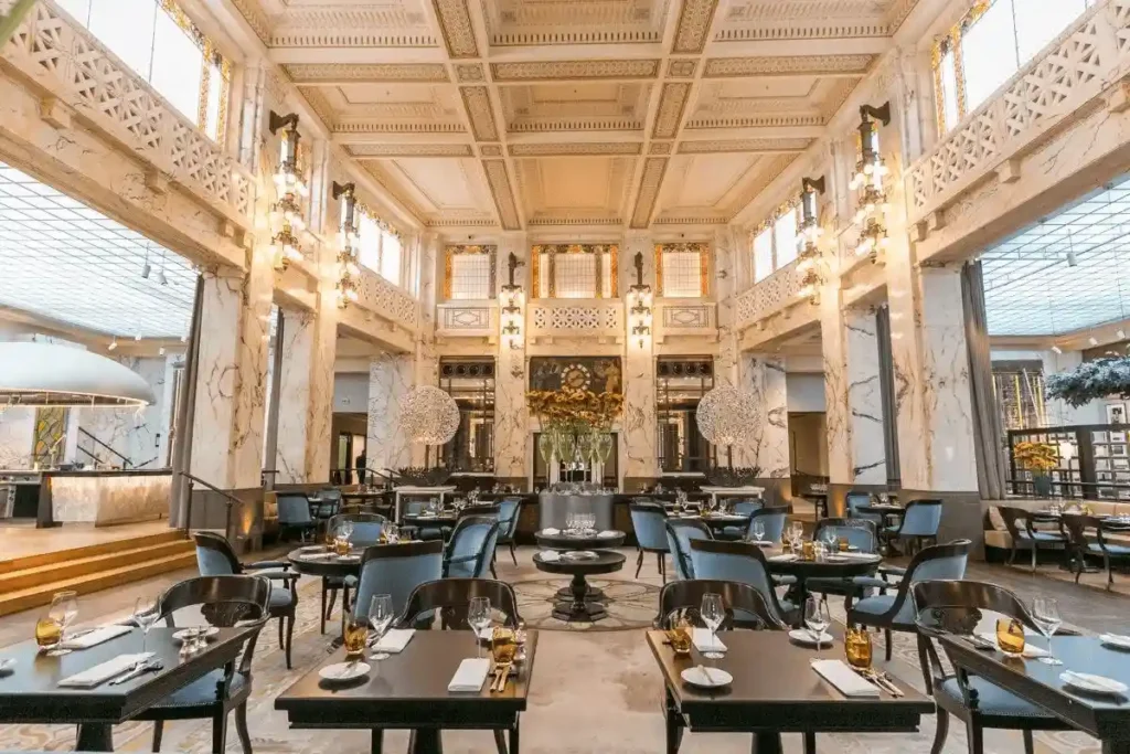 The grand dining room of The Bank Brasserie & Bar at Park Hyatt Vienna, featuring soaring marble ceilings and ornate architectural details within the former cashier hall of a 1915 bank.