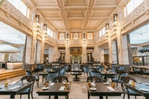 The grand dining room of The Bank Brasserie & Bar at Park Hyatt Vienna, featuring soaring marble ceilings and ornate architectural details within the former cashier hall of a 1915 bank.