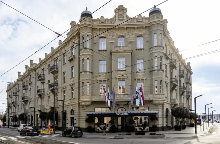 The meticulously restored Art Nouveau facade of The Bristol Belgrade, a 1912 architectural landmark featuring ornate stone carvings and classical domes in the Savamala district.
